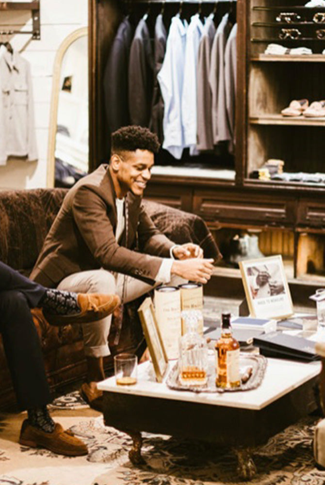 Billy Reid staff sit and chat casually with customers.