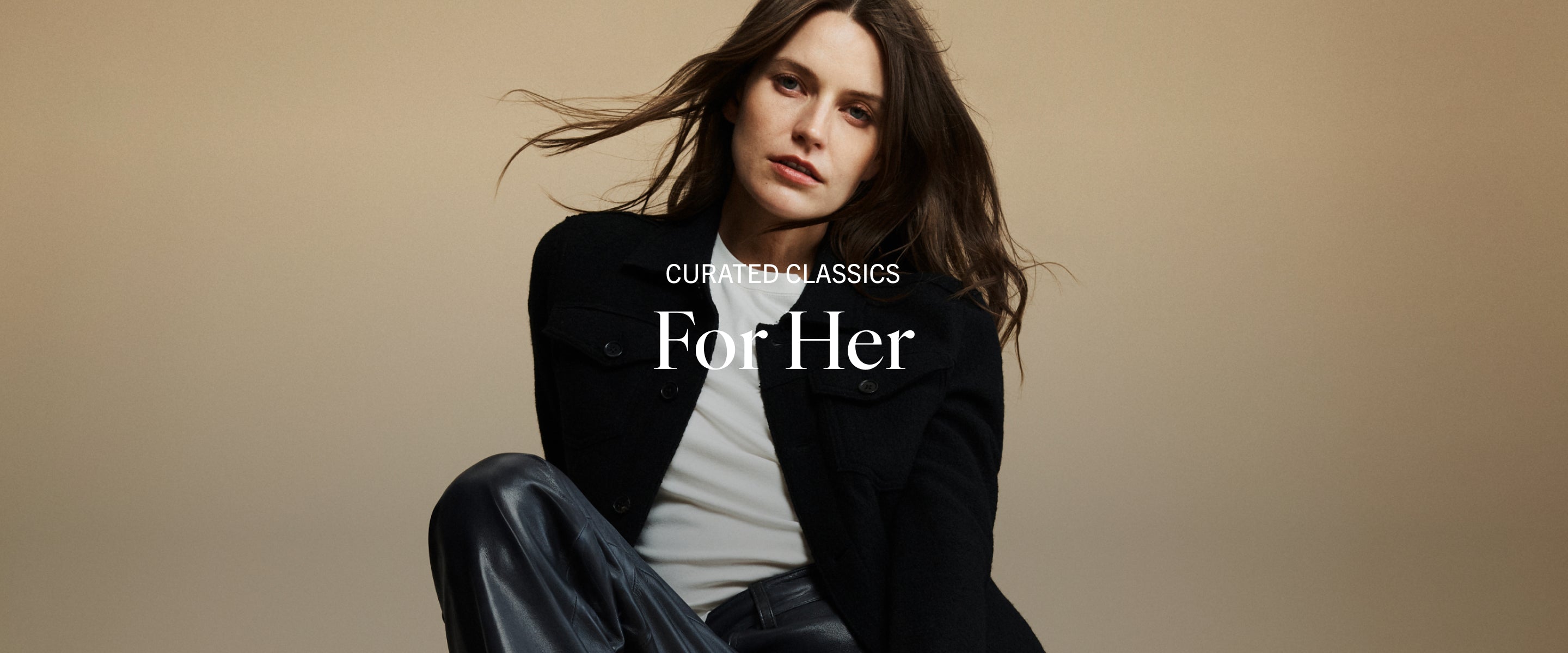 Woman in a black jacket with 'Curated Classics For Her' text on a beige background