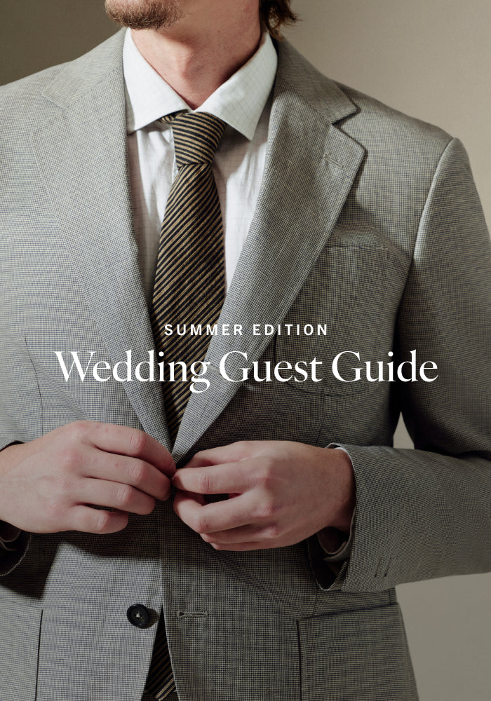 Man in gray suit with striped tie adjusting jacket, 'Summer Edition Wedding Guest Guide' text overlay.