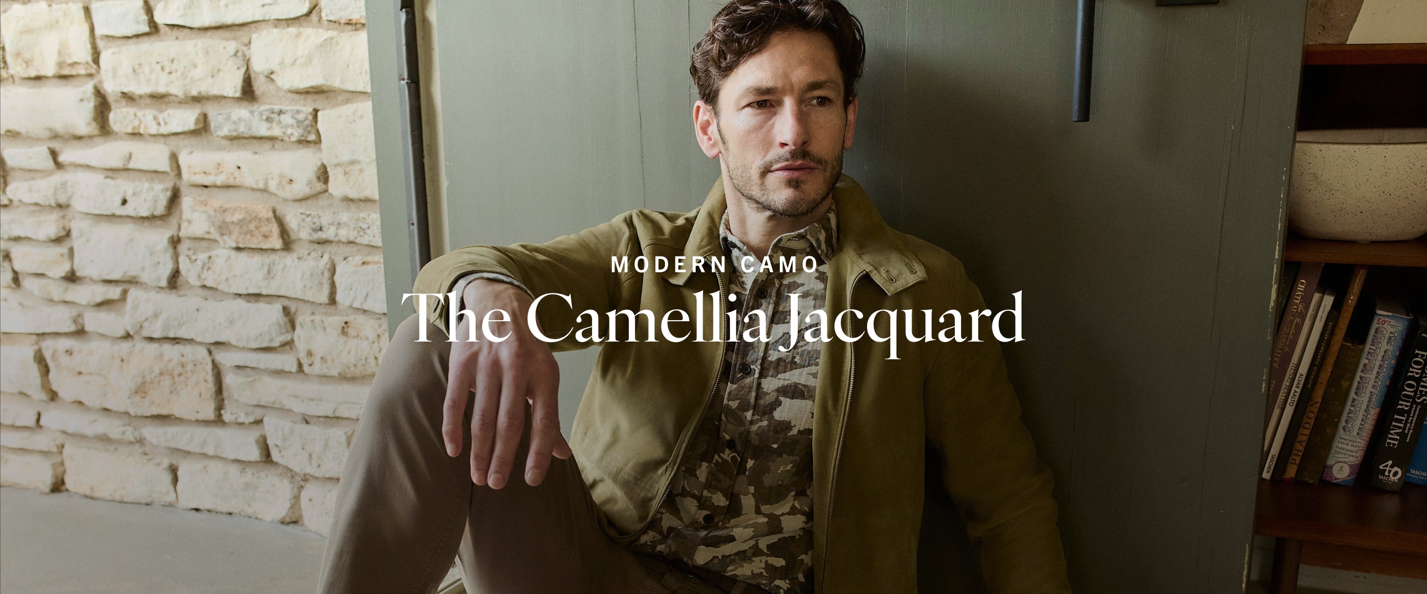 Man sitting against a wall with 'Modern Camo' branding