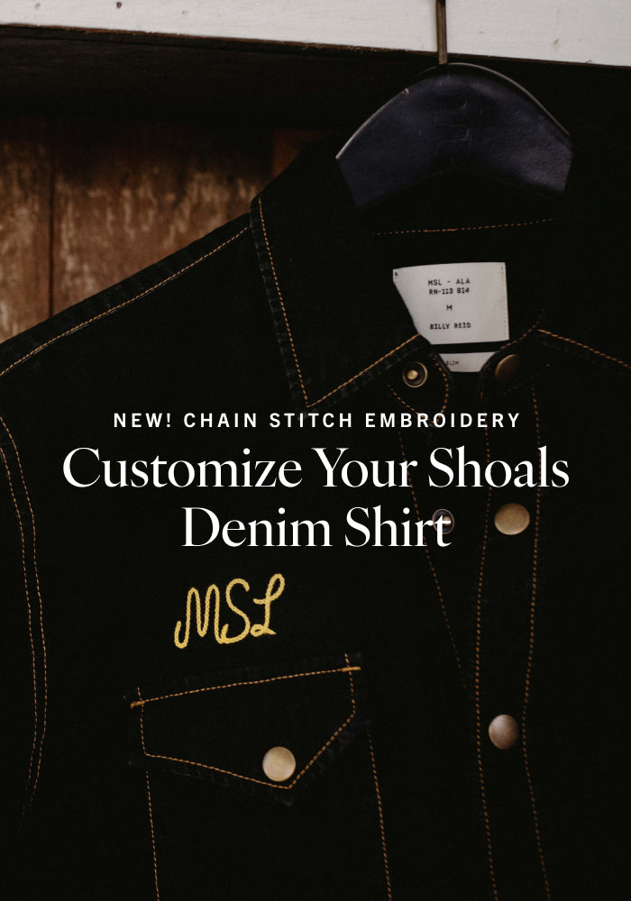 Black denim shirt with chain stitch embroidery and MSL branding on a hanger.