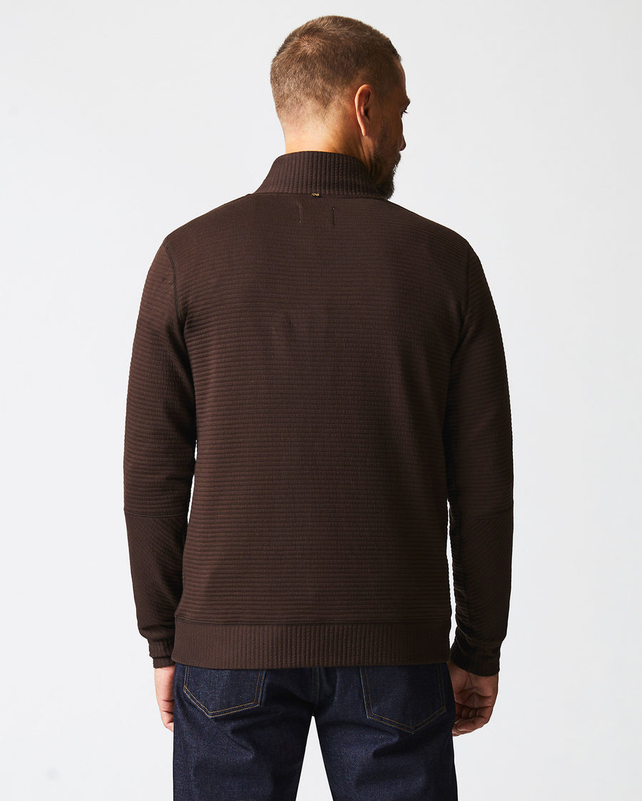 Male model wears the Quilted Half Zip in Chocolate