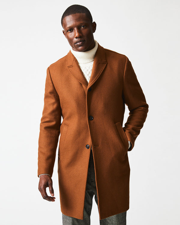 Male model wears the Walking Car Coat in Rust