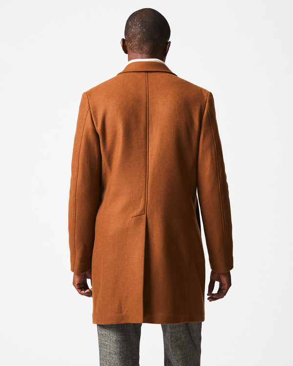 Male model wears the Walking Car Coat in Rust