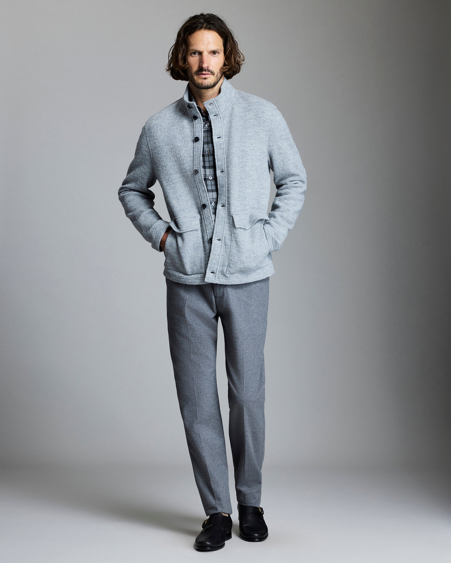 Man wearing a light gray jacket and pants against a plain background