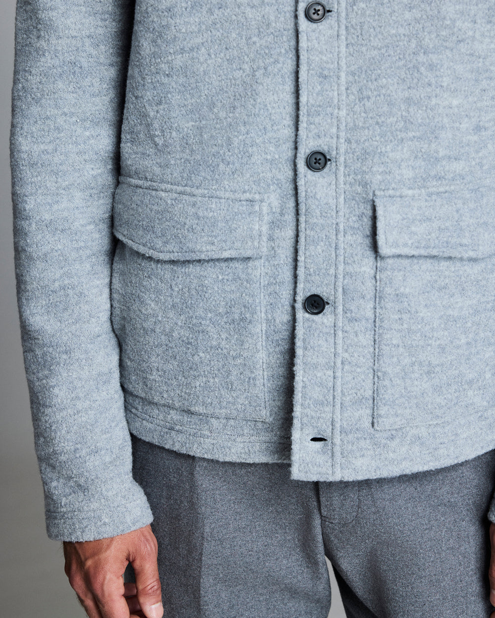 Close-up of a gray jacket with button details on a neutral background