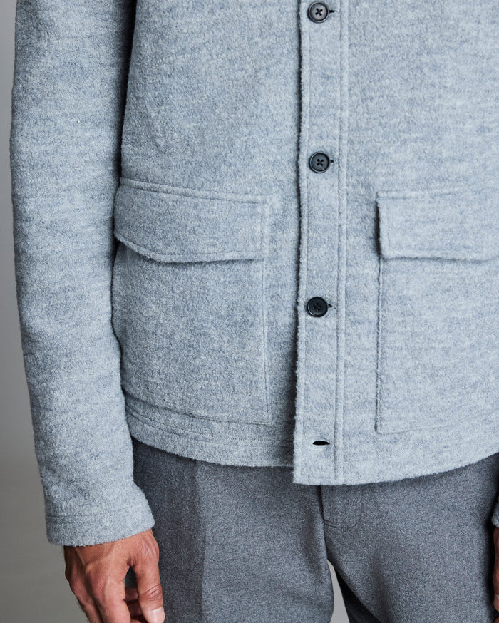 Close-up of a gray jacket with button details on a neutral background
