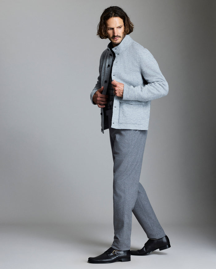 Man wearing a gray sweater and pants with a gray background