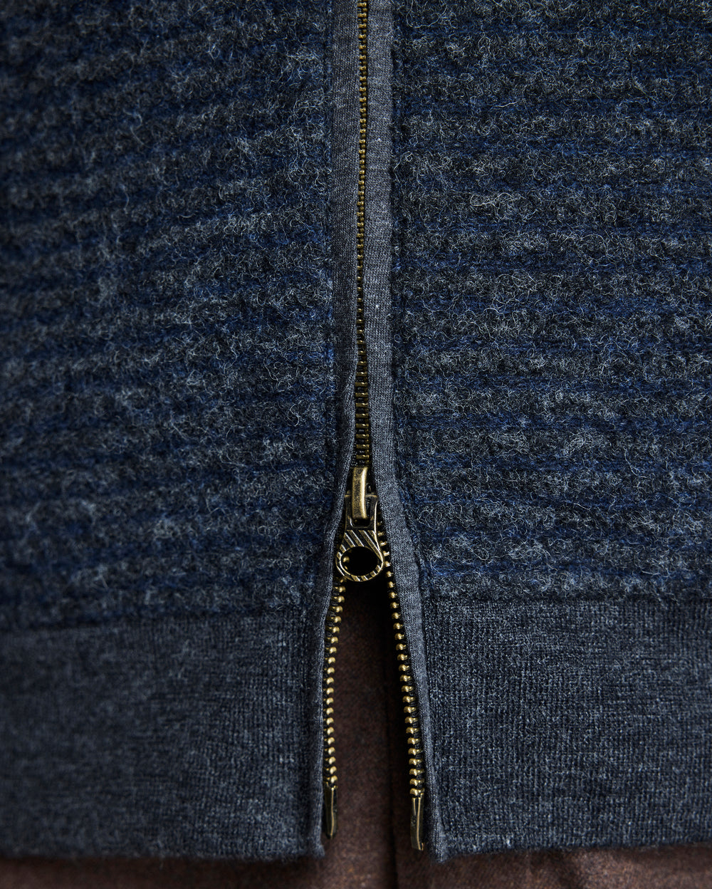Close-up of a dark blue zip-up garment with a zipper detail.