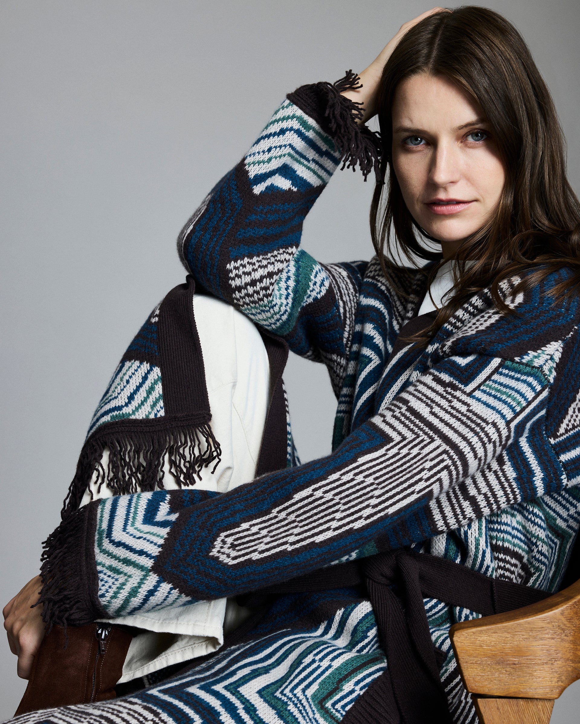 Woman wearing a patterned sweater against a gray background