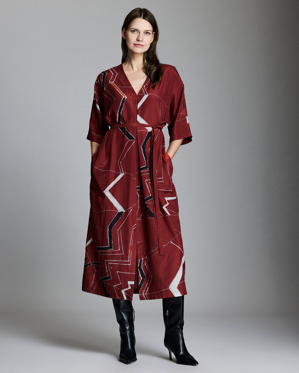Female model shows the fit of the dress Mountain Silk V Pleat Maxi Dress in Maroon