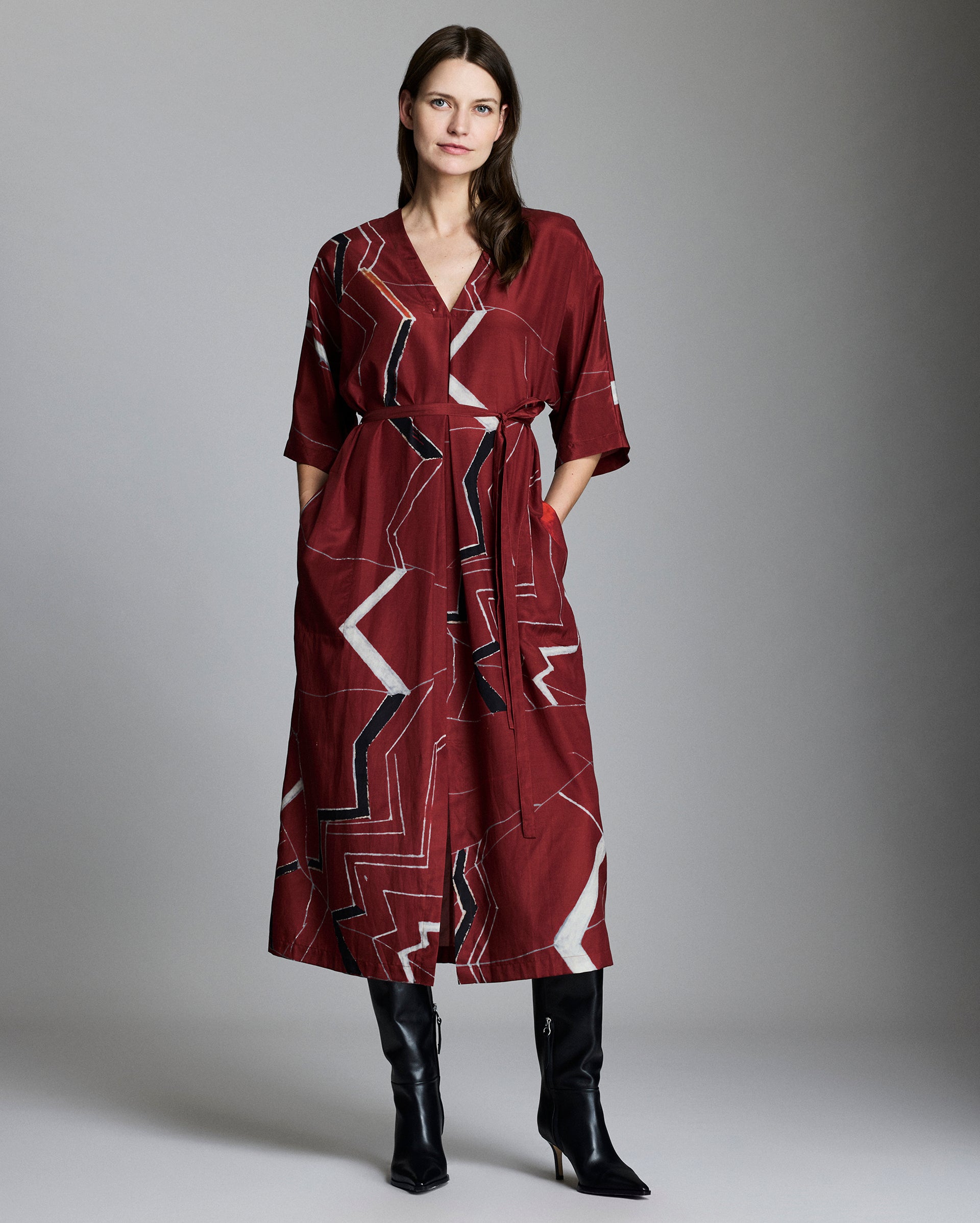 Female model shows the fit of the dress Mountain Silk V Pleat Maxi Dress in Maroon