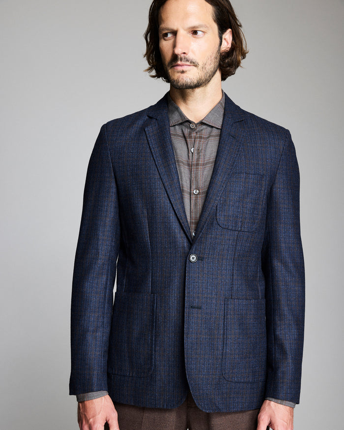 Man wearing a blue checkered suit jacket on a gray background