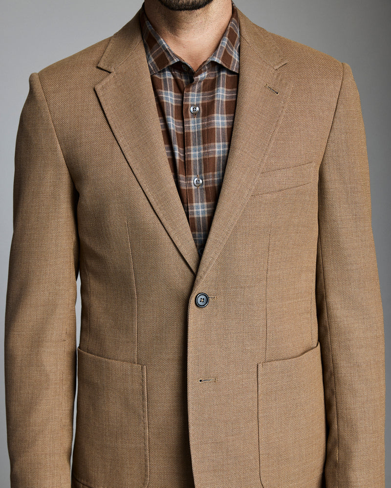 Brown blazer over a plaid shirt on a gray background Alternate