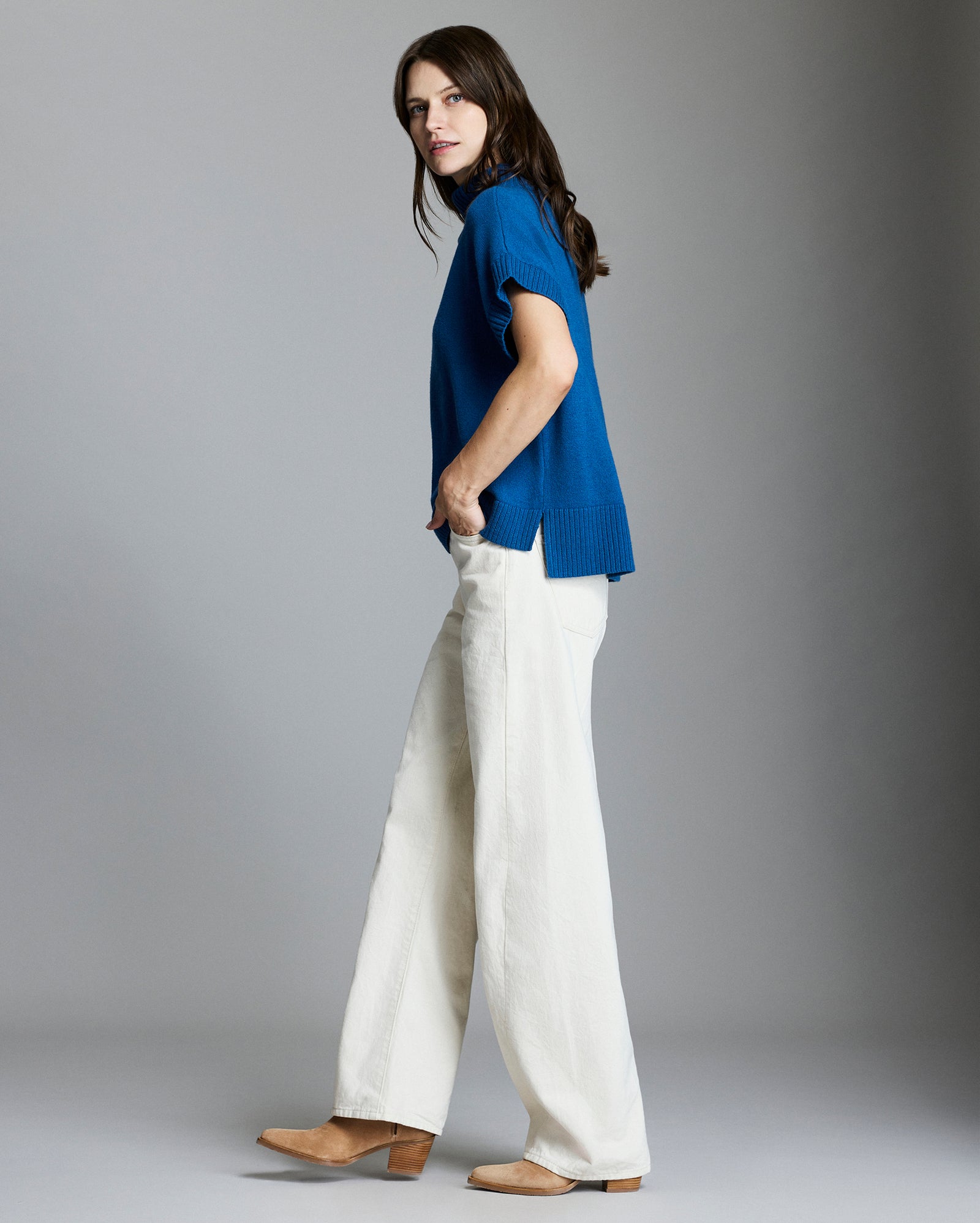Model shows the side of the sweater, which has a slightly longer back hem.