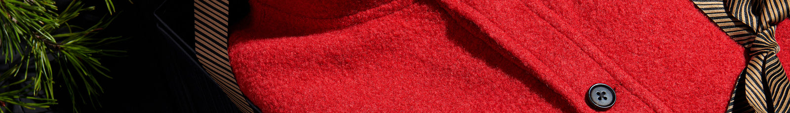 Close-up of a red fabric texture with a button and patterned trim.