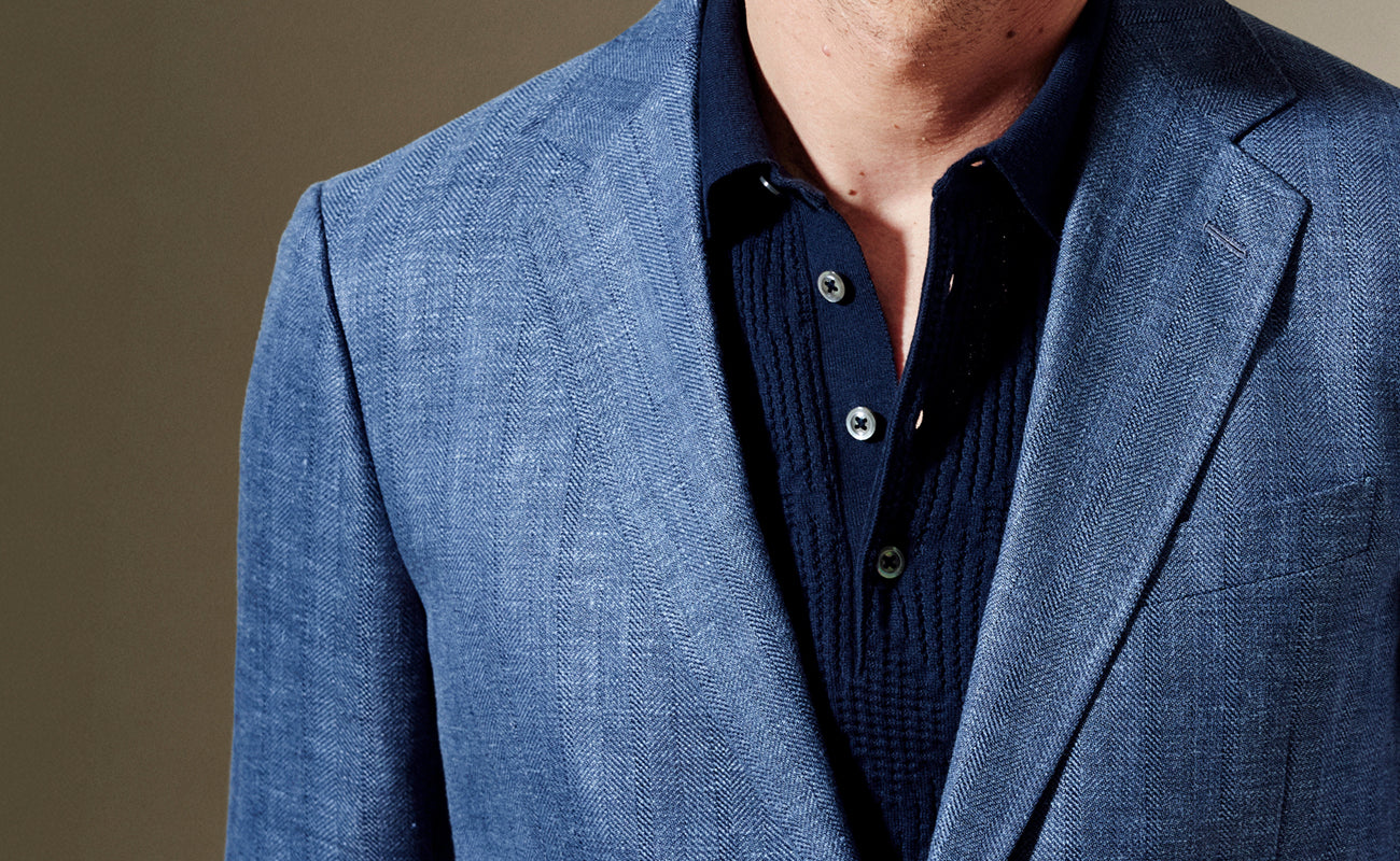 Blue blazer over a dark shirt on a brown background