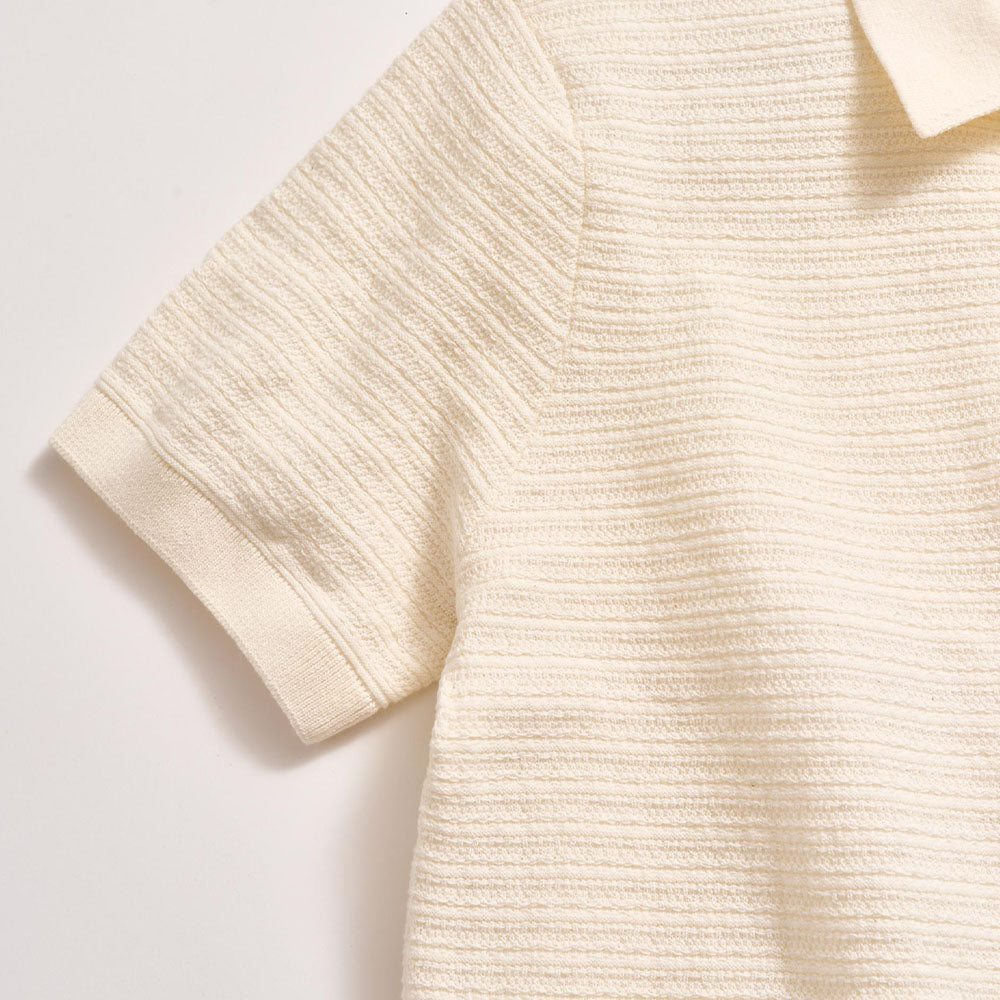 Close-up of a textured beige sweater on a light background