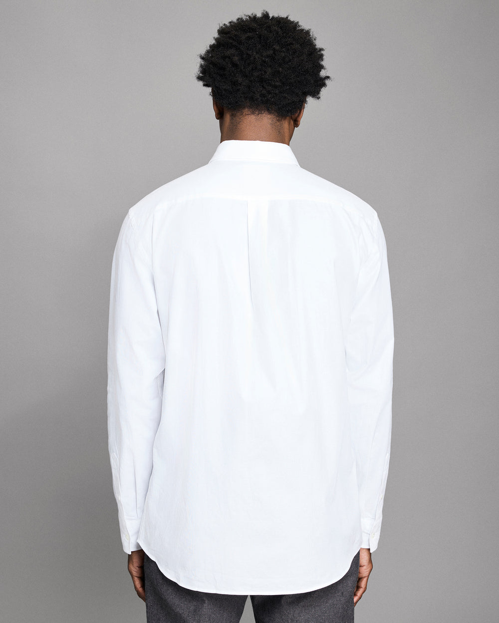 Person wearing a white shirt with a gray background