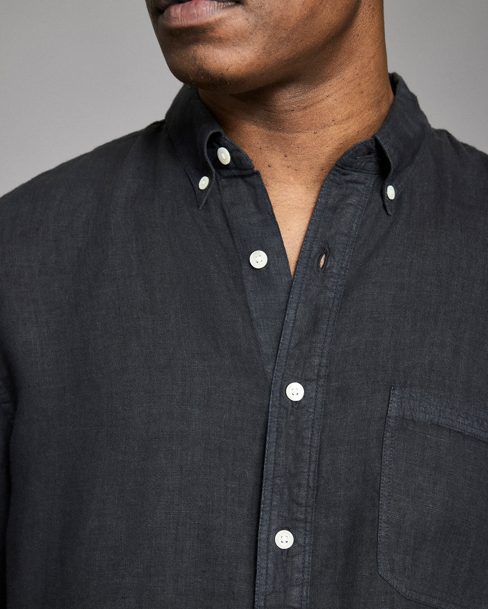 Dark gray button-up shirt worn by a person against a neutral background