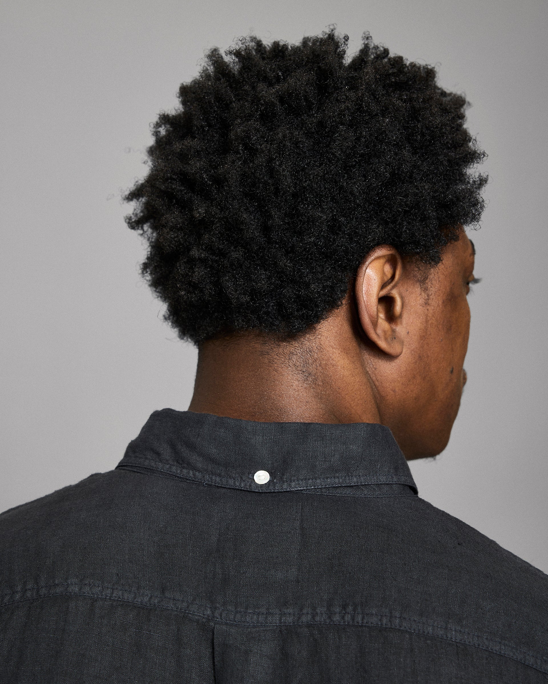 Person wearing a black shirt with a gray background