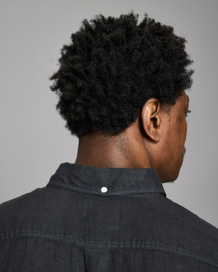 Person wearing a black shirt with a gray background