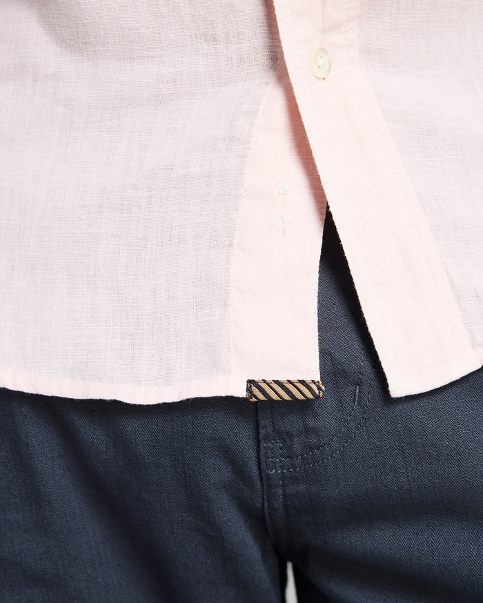 Close-up of a white shirt with a collar and navy pants.
