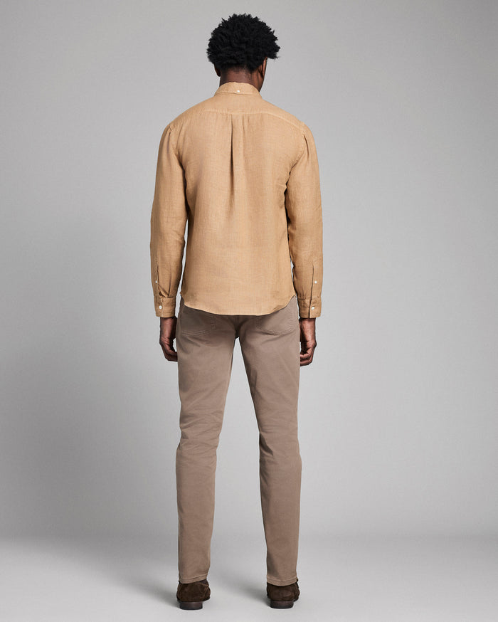 Man wearing a beige jacket and pants against a gray background