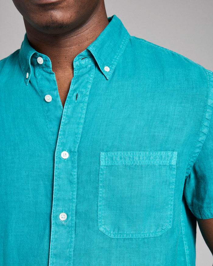 Teal button-up shirt worn by a person on a gray background