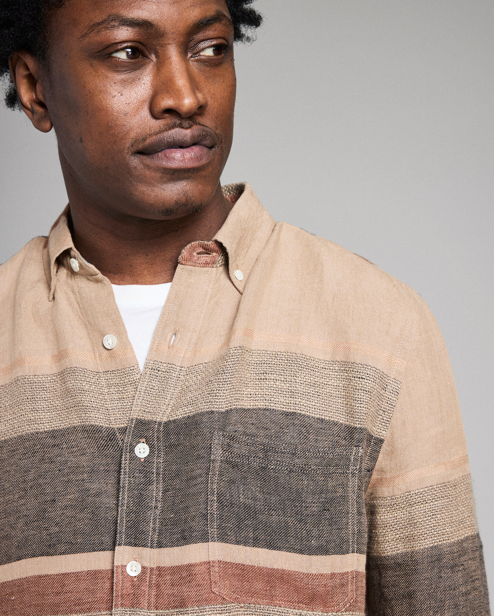Man wearing a striped shirt with a neutral background