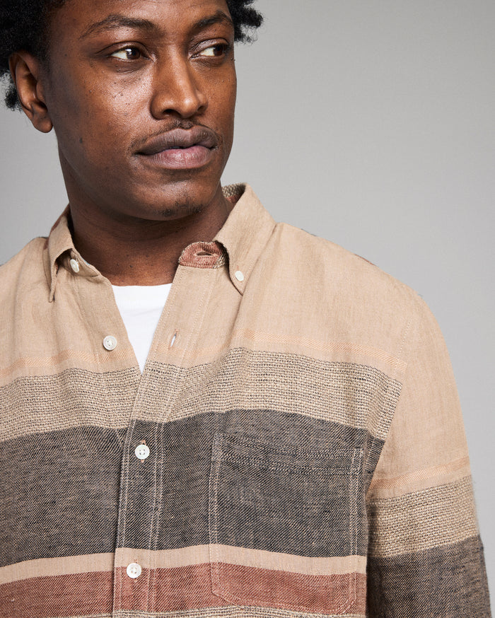 Man wearing a striped shirt with a neutral background