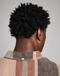 Person wearing a plaid shirt with a neutral background
