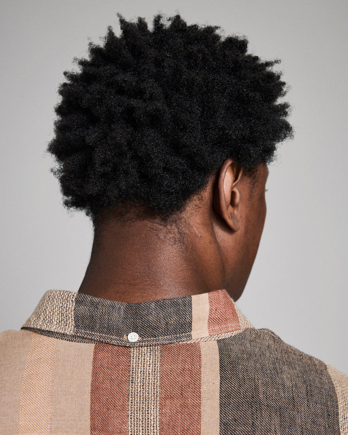 Person wearing a plaid shirt with a neutral background