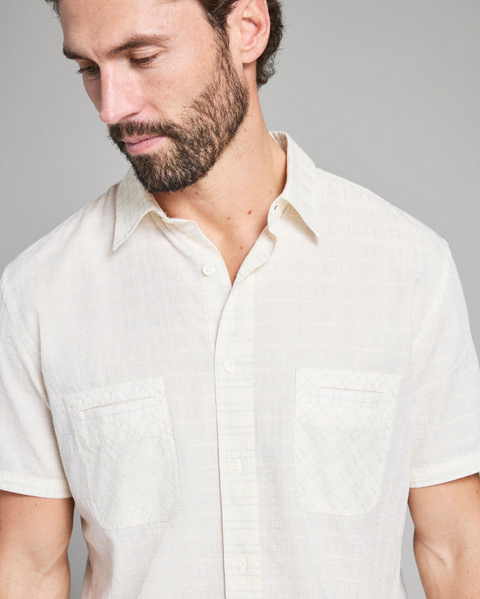 Man wearing a light-colored shirt against a plain background