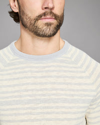 Close-up of a person wearing a striped sweater against a gray background