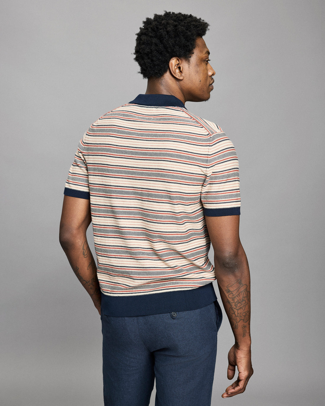 Model wears a striped polo on a light gray background