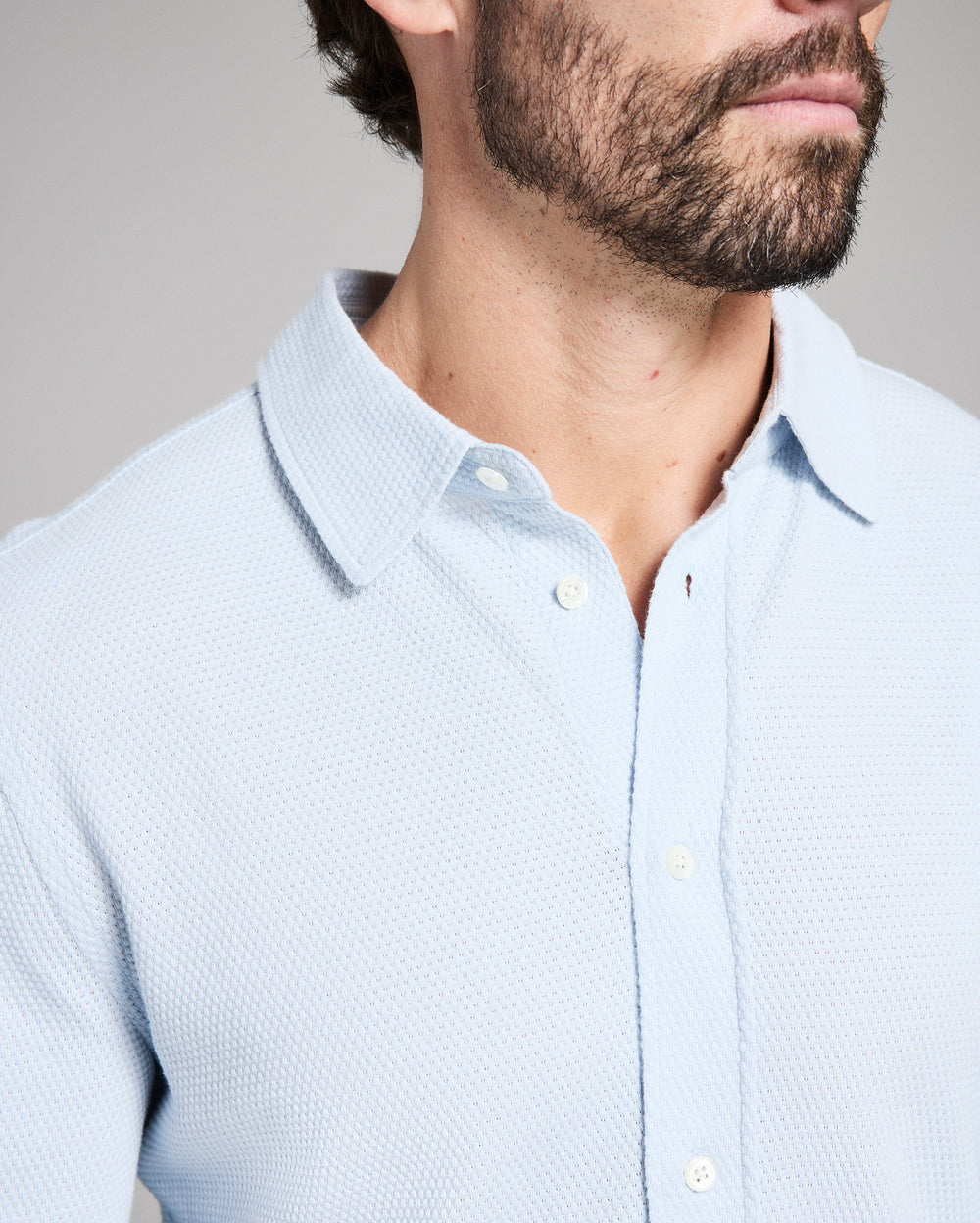 Light blue textured shirt worn by a person with a neutral background