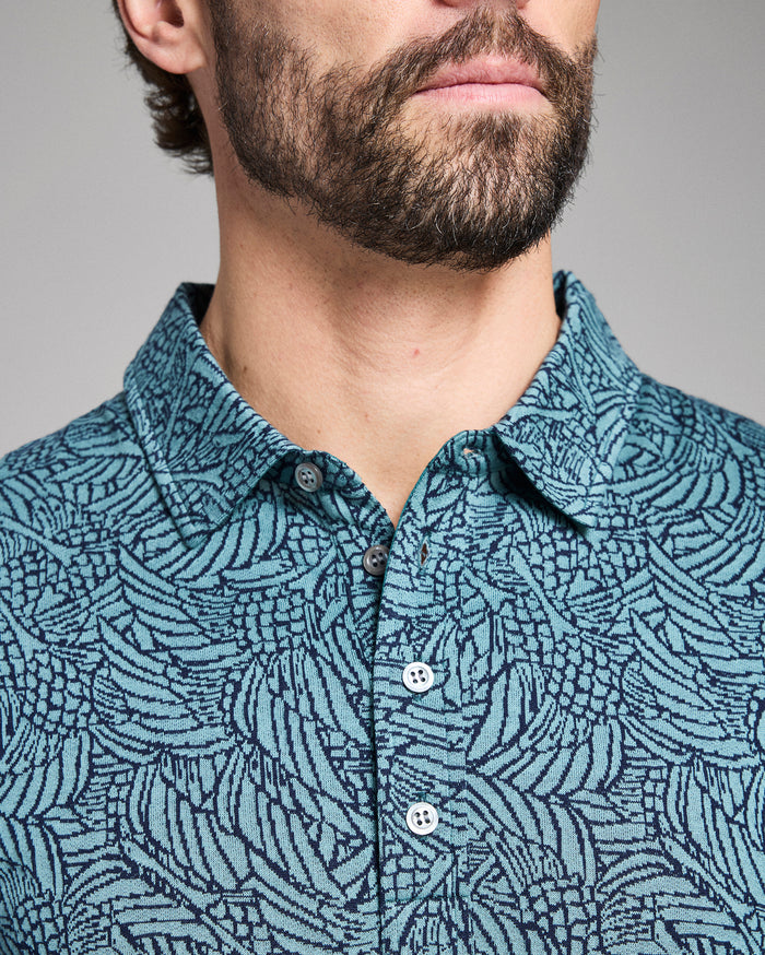 Man wearing a blue patterned shirt against a gray background