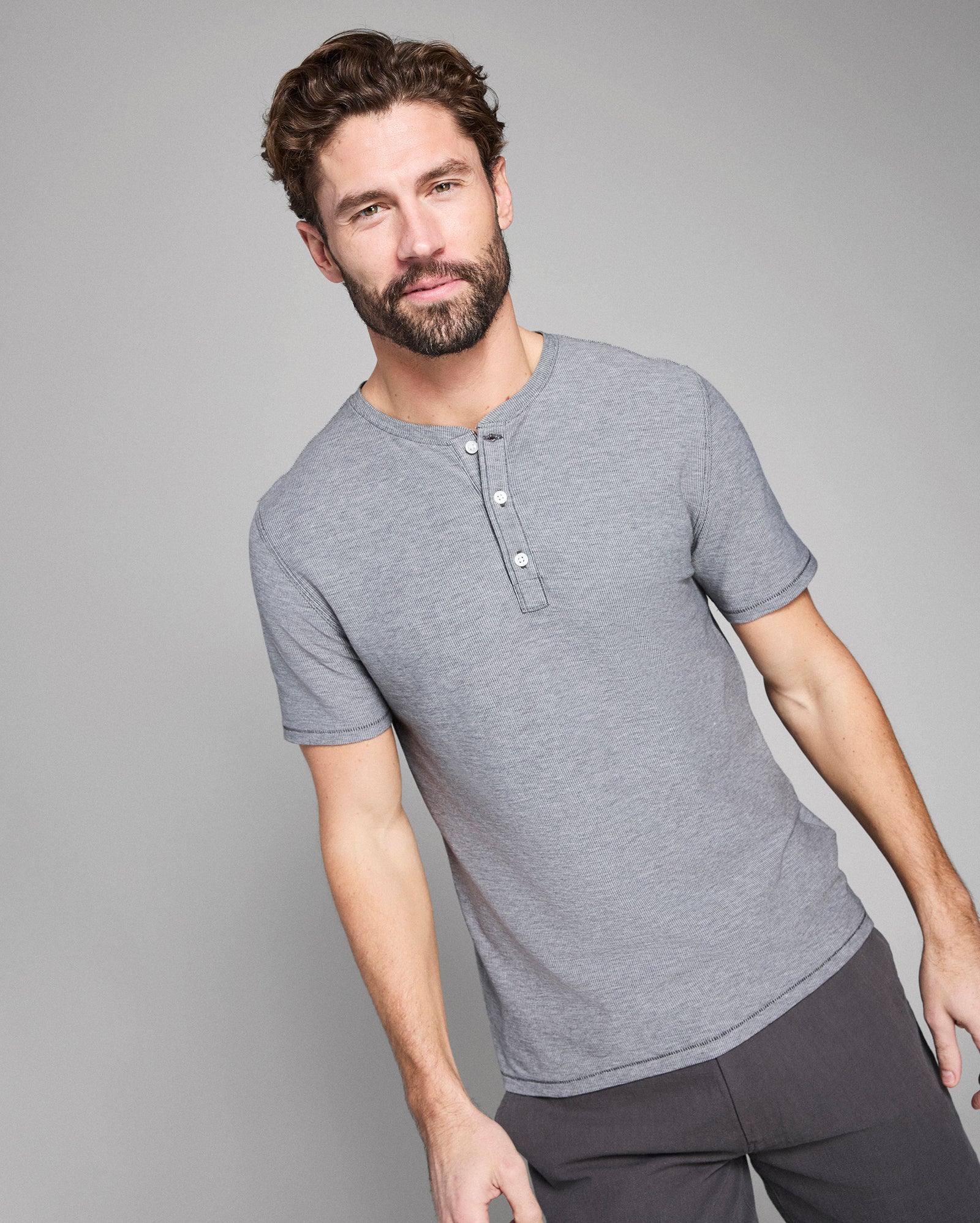 Man wearing a gray henley shirt against a plain background