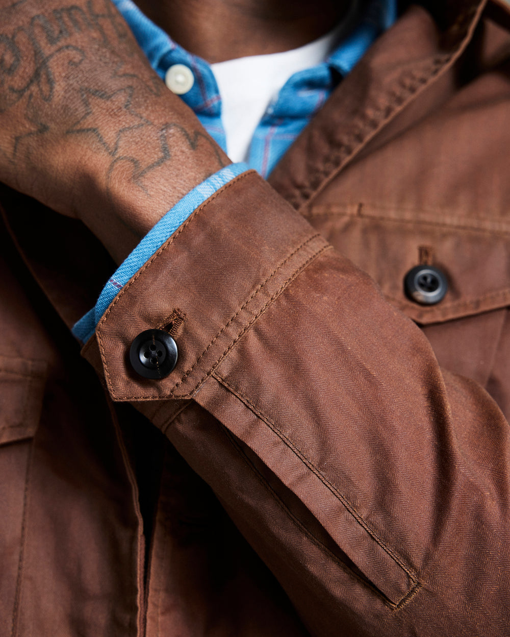 Close-up of a brown jacket with blue lining and visible buttons.