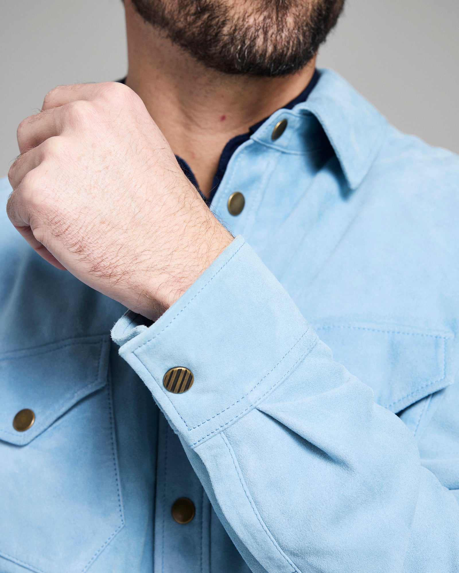 Light blue jacket with button details worn by a person, focusing on the collar and buttons.