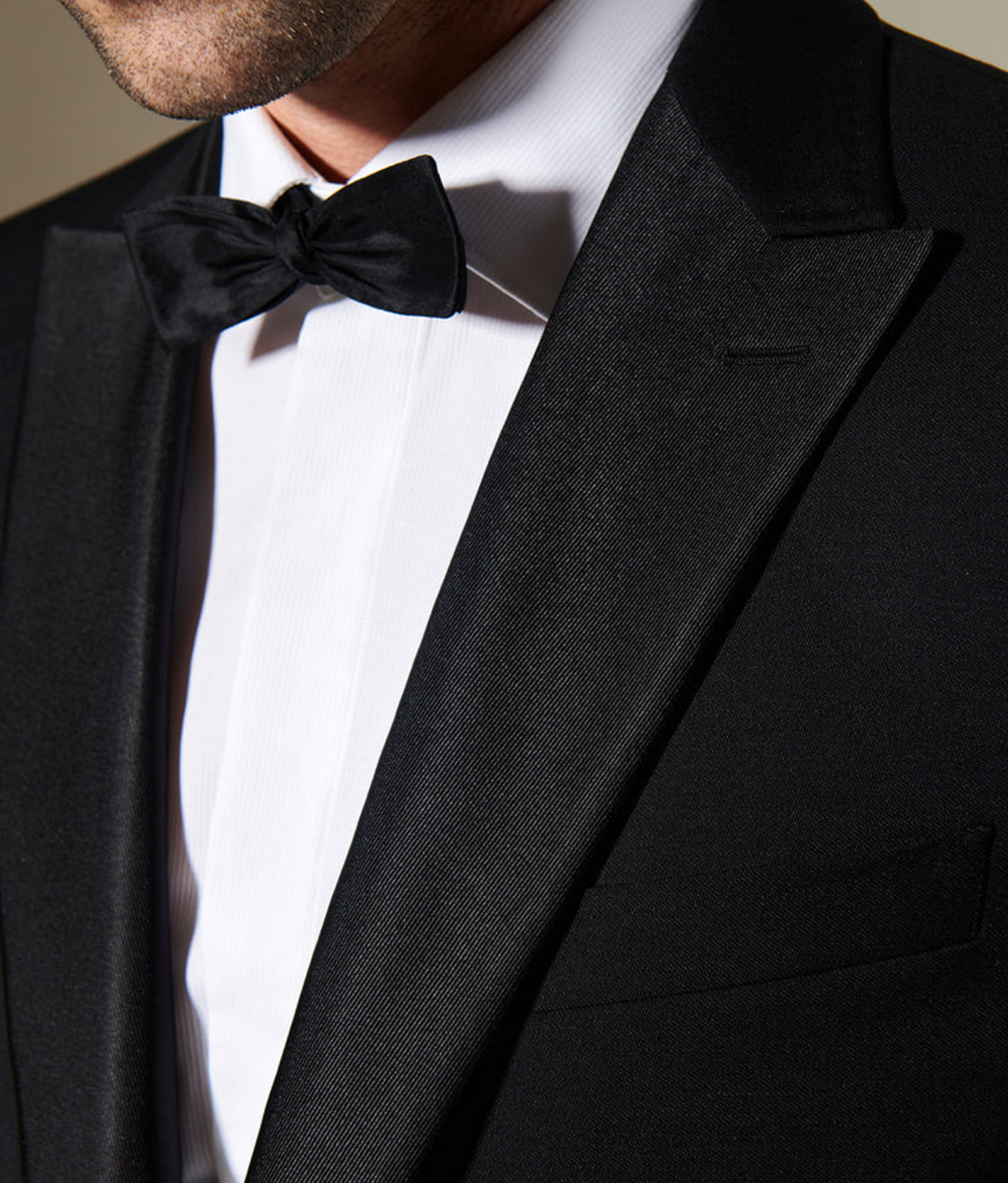 Close-up of a person wearing a black tuxedo with a bow tie.