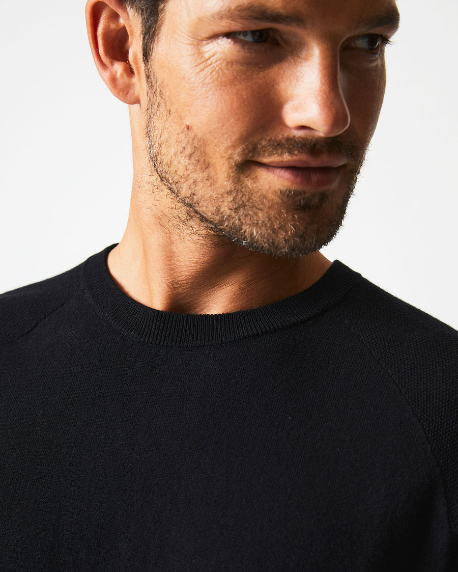 Male model wears the Baseball Sweater Crew in Black