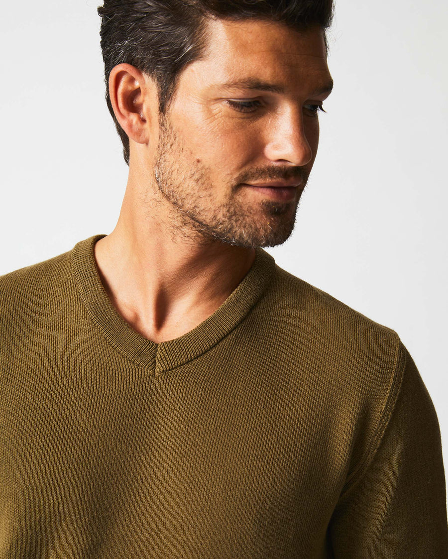 Male model wears the American V Neck Sweater in Olive