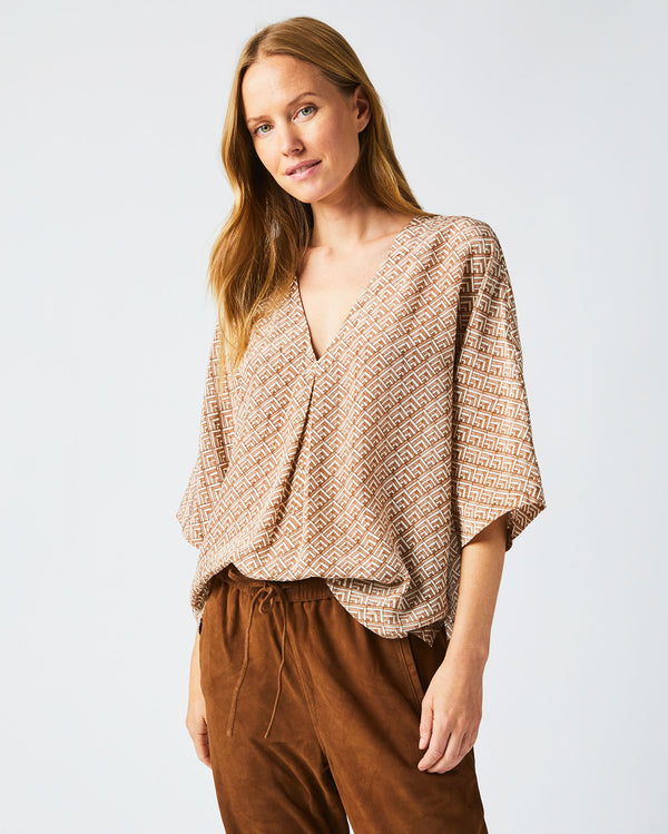 Female model wears the V Pleat Blouse in Cream/Brown