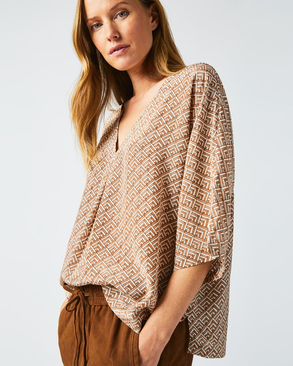 Female model wears the V Pleat Blouse in Cream/Brown