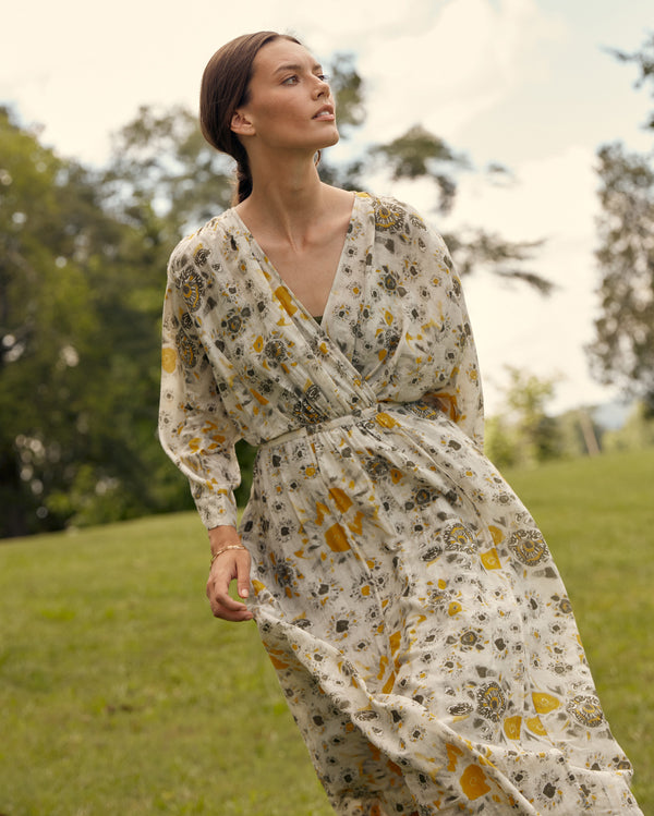 Female model wears the robe wrap dress in ivory/gold