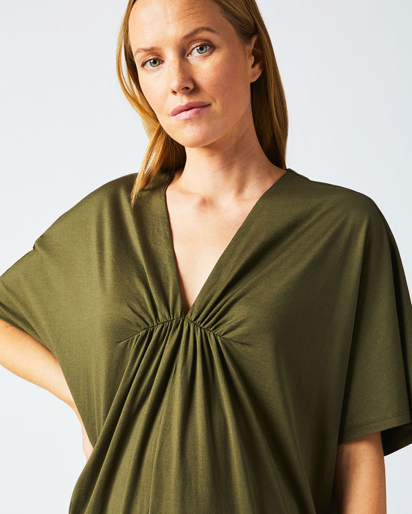 Female model wears the Cocoon Knit Dress in Dark Green