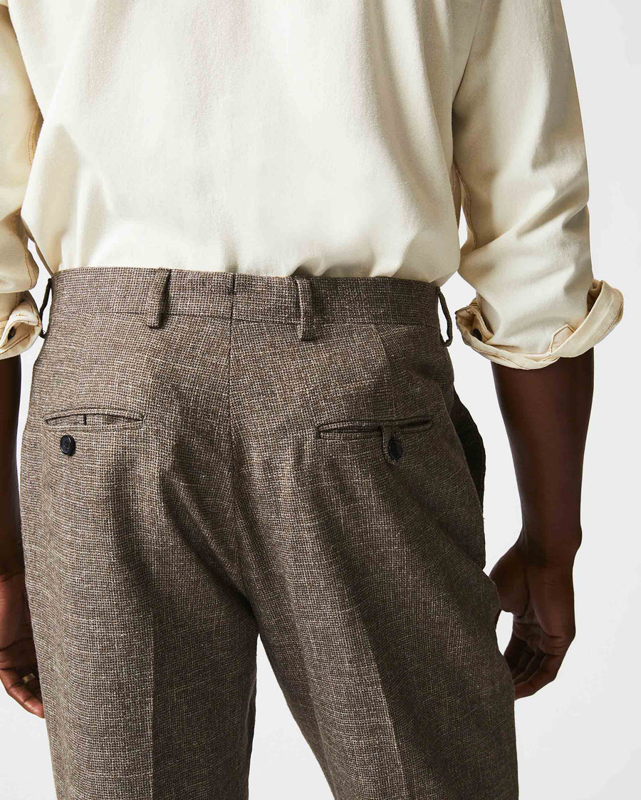 Male model wears the Flat Front Trouser in Black/Brown