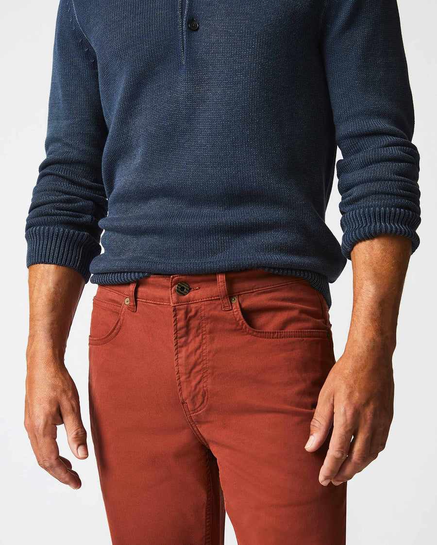 Male model wears the 5 Pocket Pant in Rust Red